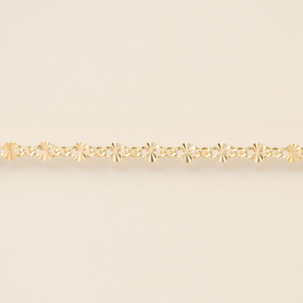 Gold bracelet on a beige background