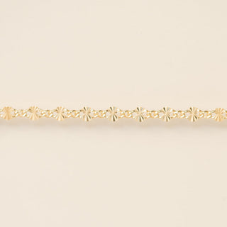 Gold bracelet on a beige background