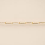 Gold chain necklace on a beige background