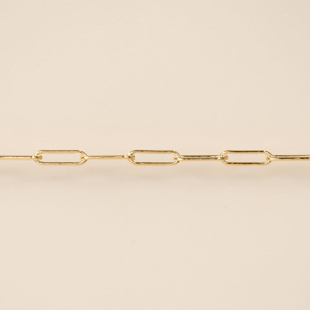 Gold chain necklace on a beige background