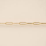 Gold chain necklace on a beige background