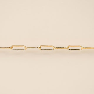 Gold chain necklace on a beige background