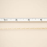 Gold chain on a beige background with a ruler for scale