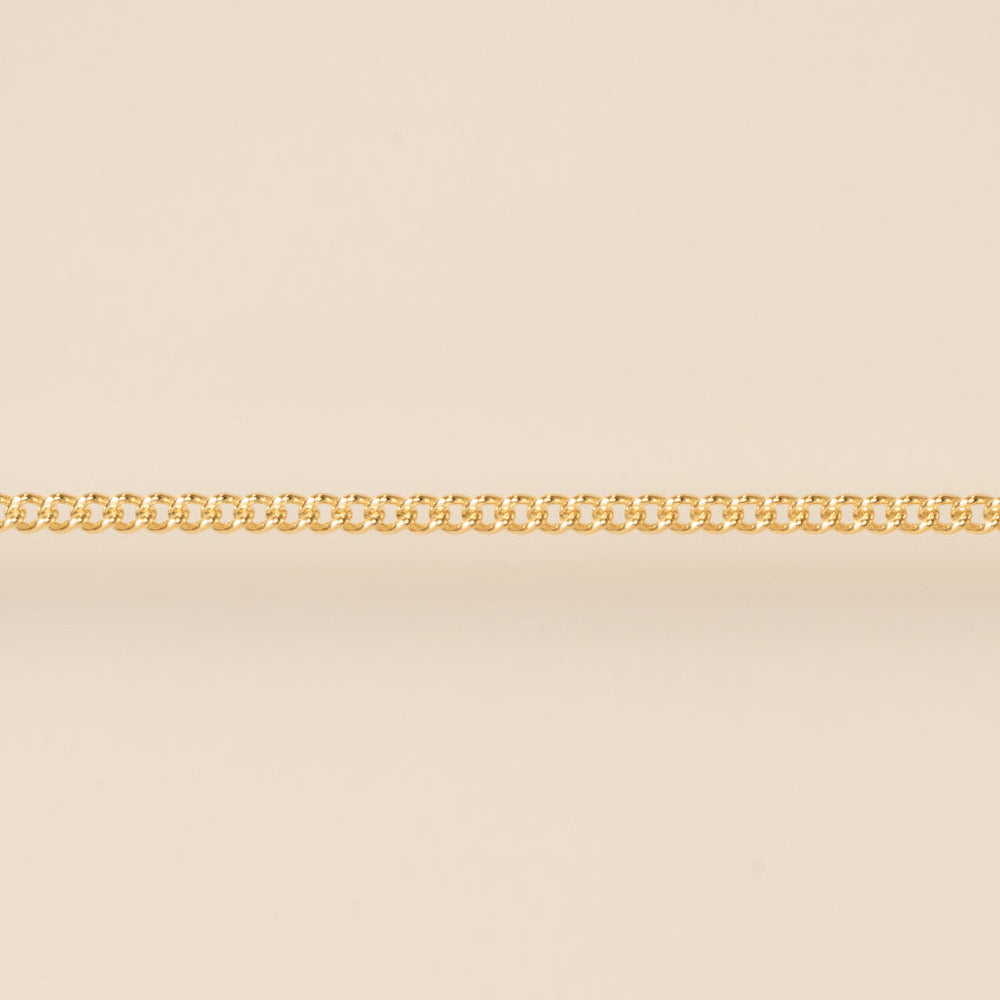 Gold chain on a beige background for permanent jewelry