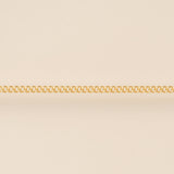 Gold chain on a beige background for permanent jewelry