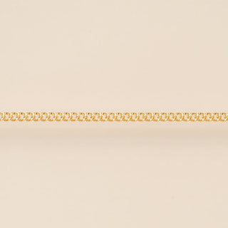 Gold chain on a beige background for permanent jewelry