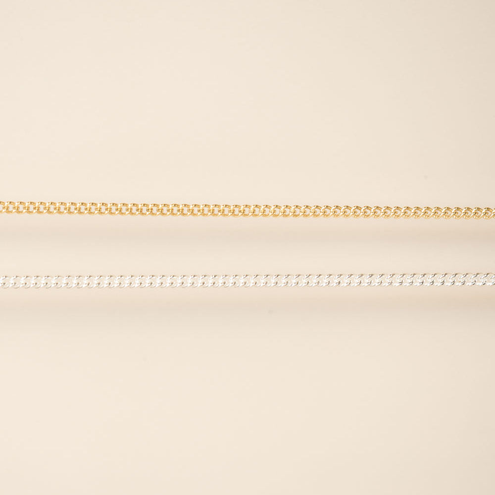 Two chains on a beige background gold and silver for permanent jewelry