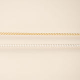 Two chains on a beige background gold and silver for permanent jewelry