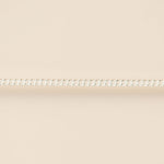 Thin silver chain on a beige background