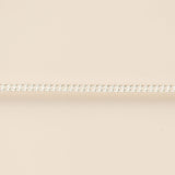 Thin silver chain on a beige background