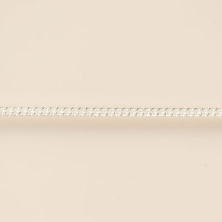Thin silver chain on a beige background