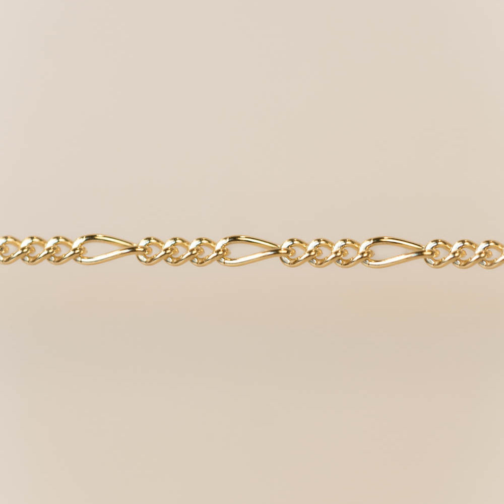 Gold chain bracelet on a beige background for permanent jewelry