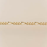 Gold chain bracelet on a beige background for permanent jewelry