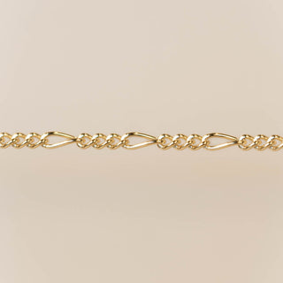Gold chain bracelet on a beige background for permanent jewelry