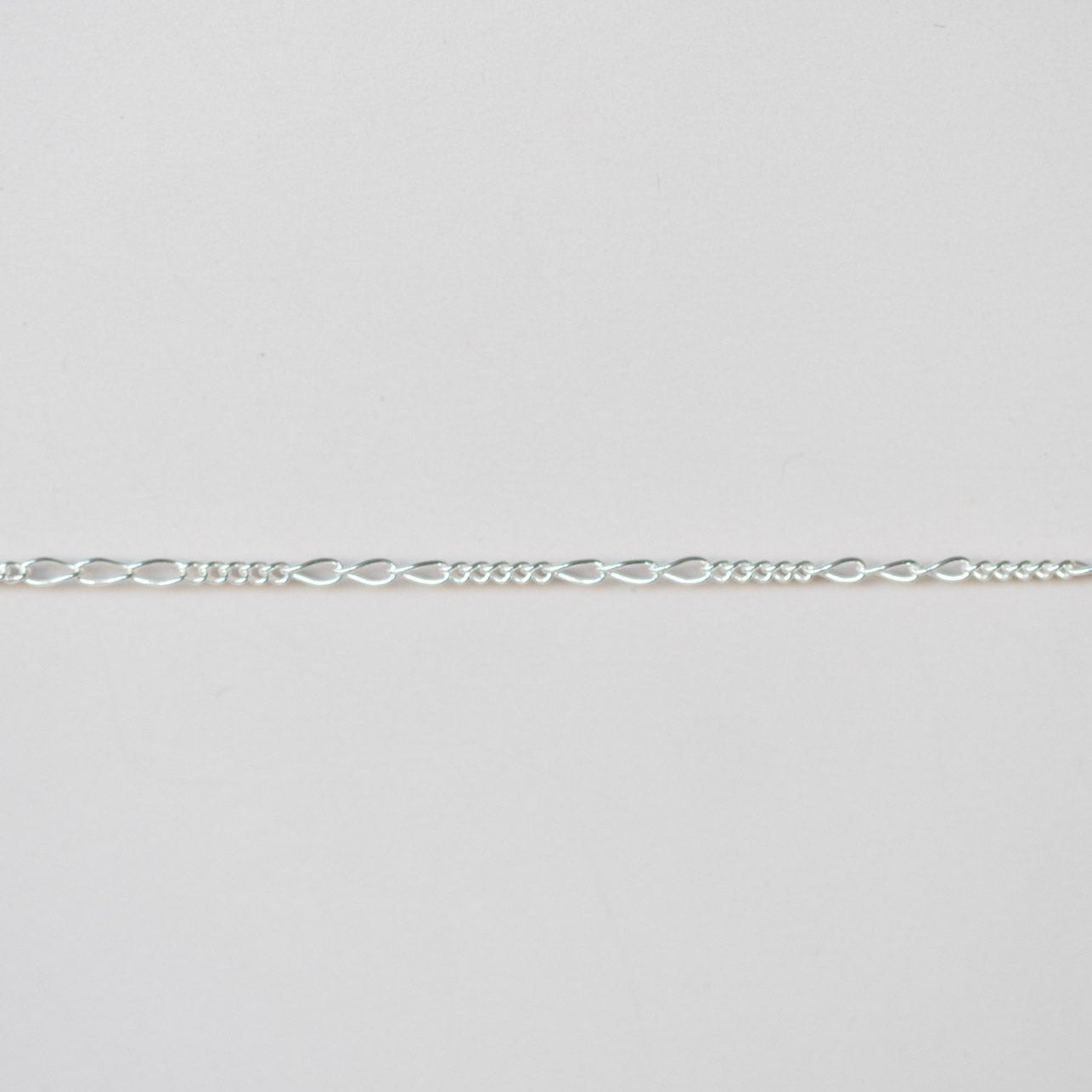 Silver chain on a light gray background