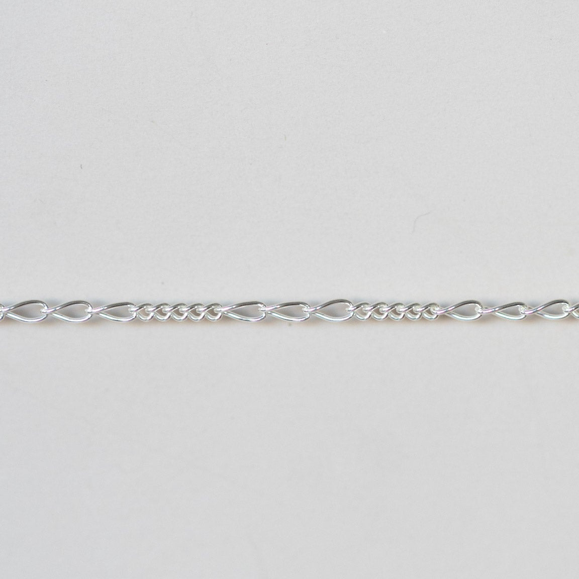 Silver chain on a light gray background