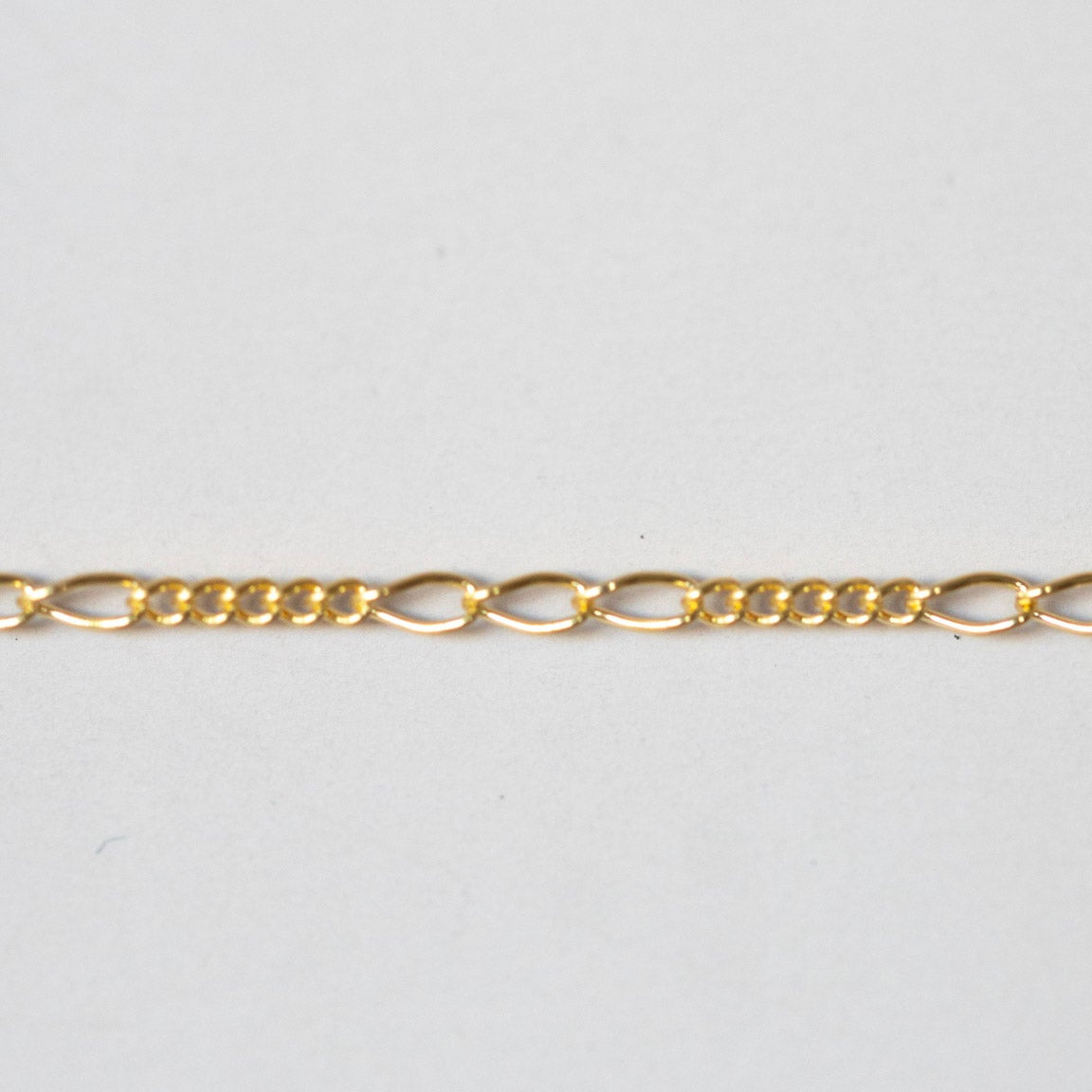 Gold chain on a light gray background