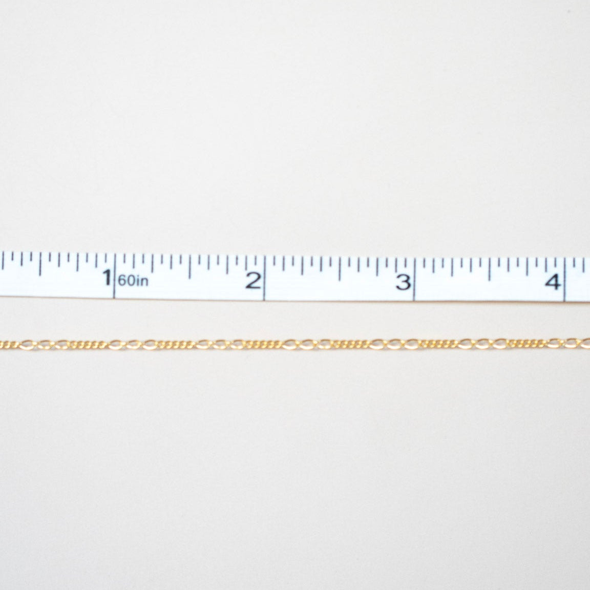 Gold chain on a white background with a ruler for scale