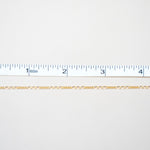 Gold chain on a white background with a ruler for scale
