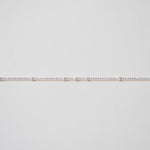 Thin silver chain on a light gray background