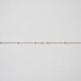 Thin silver chain on a light gray background