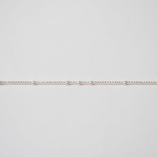 Thin silver chain on a light gray background