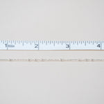 White fabric swatch with a ruler at the bottom for scale