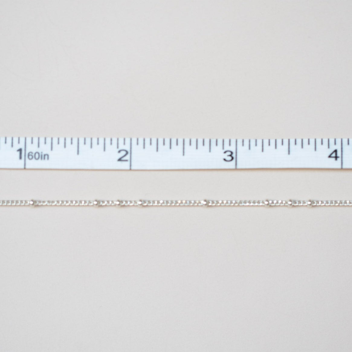 White fabric swatch with a ruler at the bottom for scale