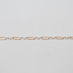 Gold chain on a light gray background