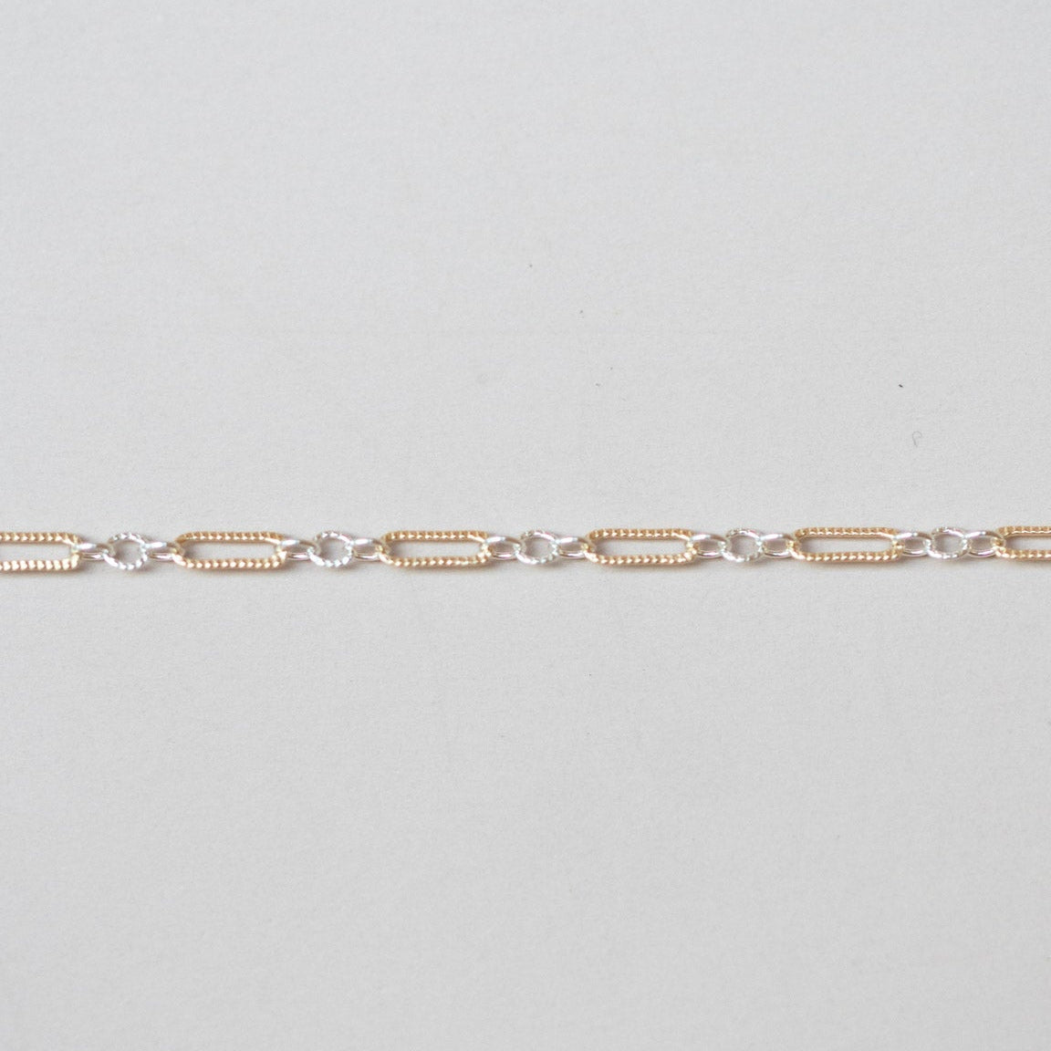 Gold chain on a light gray background