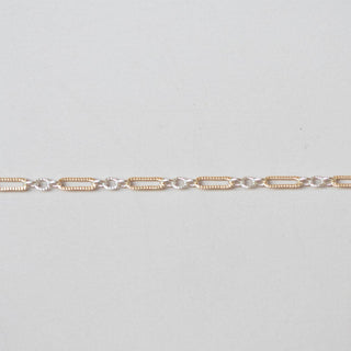Gold chain on a light gray background