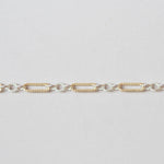 Gold and silver chain bracelet on a light gray background
