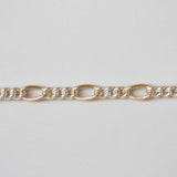 Gold chain bracelet on a light gray background