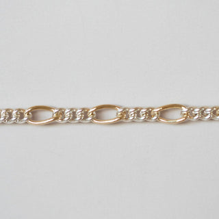 Gold chain bracelet on a light gray background