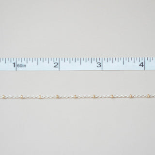 Gold chain with a ruler on a light gray background