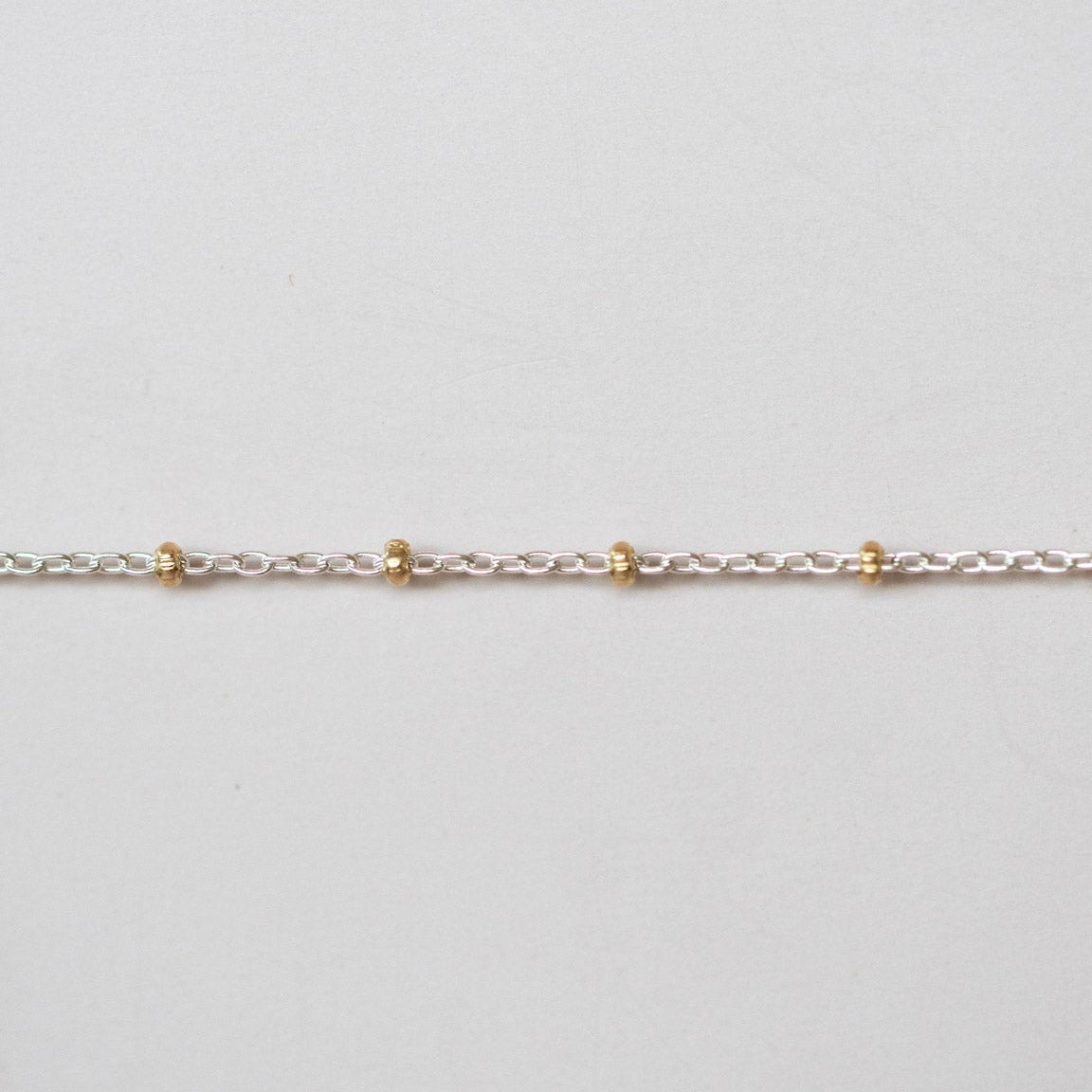 Gold chain on a light gray background