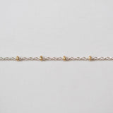 Gold chain on a light gray background
