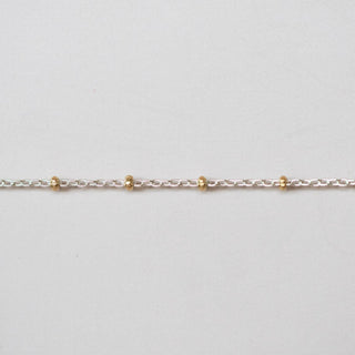Gold chain on a light gray background