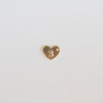 Heart-shaped gold charm with the number 3 on a light gray background