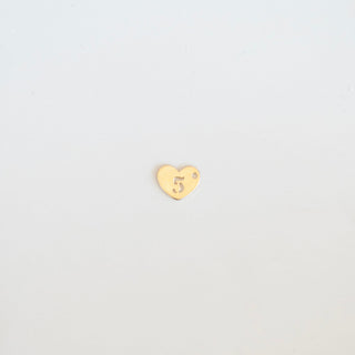 Gold heart-shaped charm with a number '5' on a light gray background