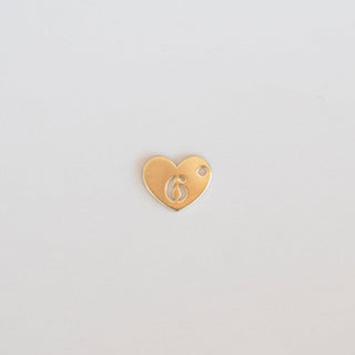 Gold heart-shaped charm with number 6 on a light gray background