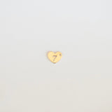 Gold heart-shaped charm with a number '7' on a light gray background