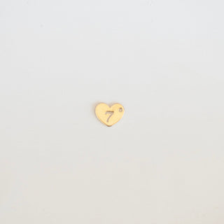 Gold heart-shaped charm with a number '7' on a light gray background