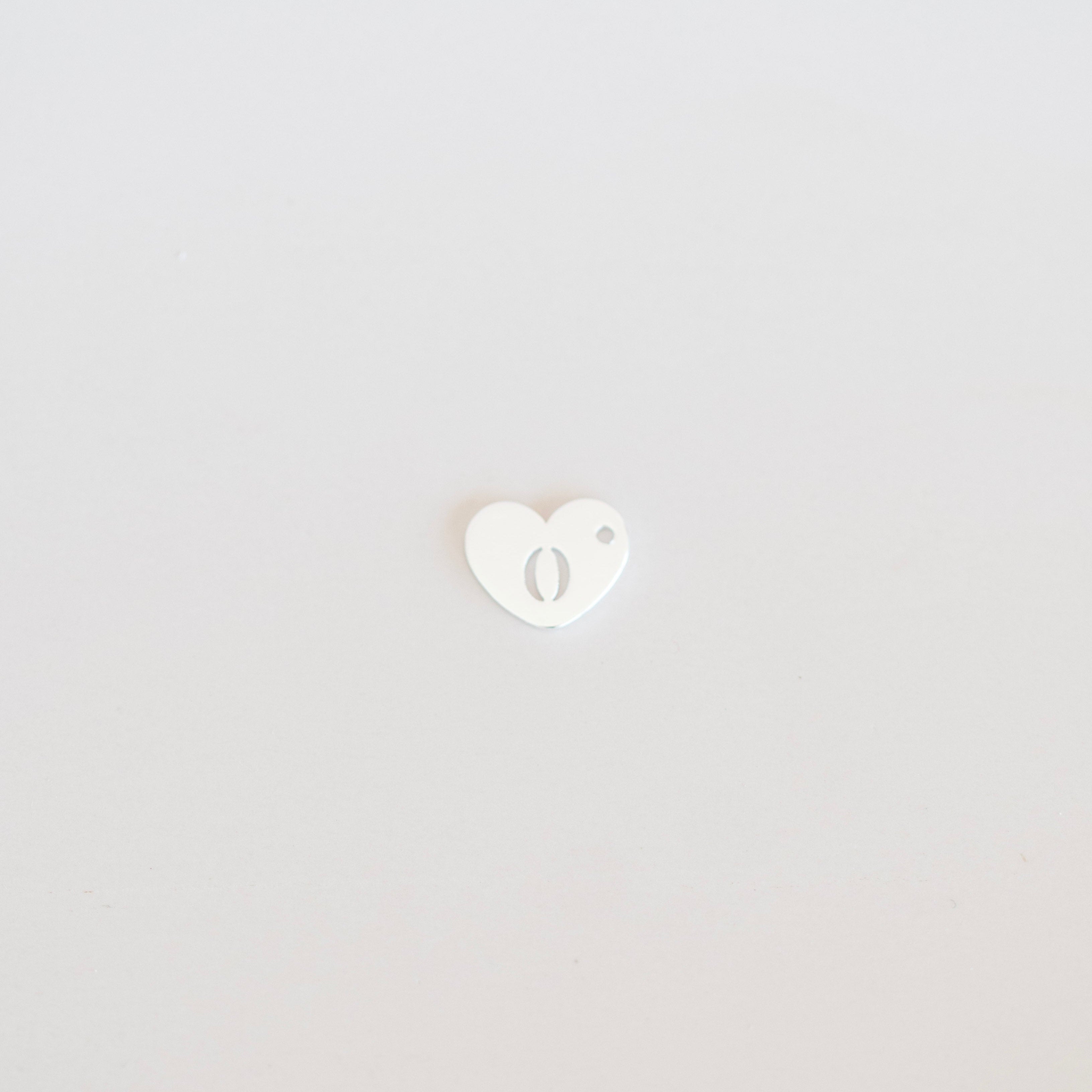 Small white heart-shaped object on a light gray background