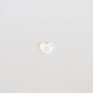 Small white heart-shaped object on a light gray background