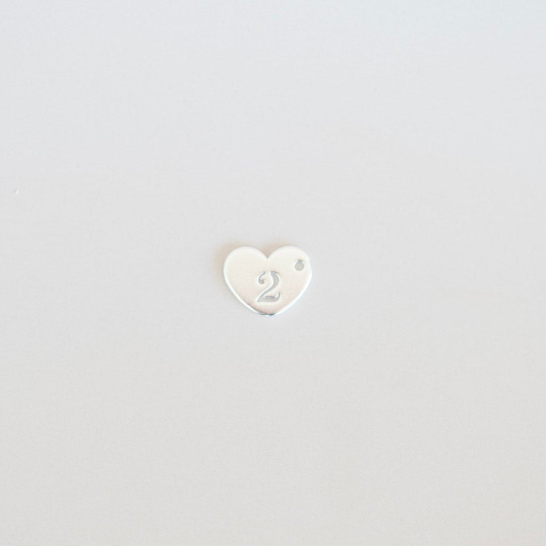 Small white heart-shaped object on a light gray background