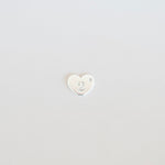 Small white heart-shaped object on a light gray background