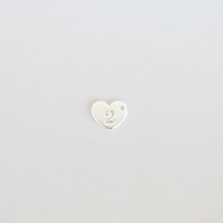 Small white heart-shaped object on a light gray background