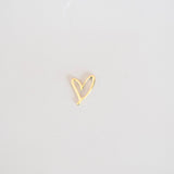 Gold heart-shaped earring on a light gray background