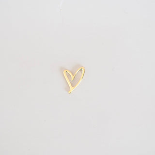 Gold heart-shaped earring on a light gray background